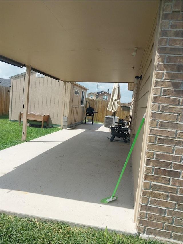 view of patio / terrace with grilling area, central AC, fence, and an outdoor structure
