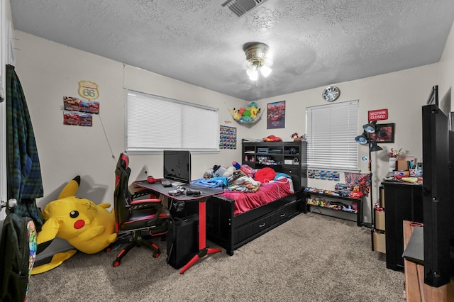 bedroom featuring a textured ceiling, visible vents, and carpet