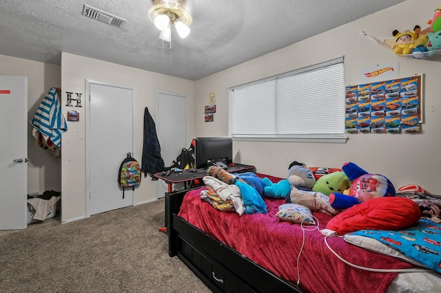 carpeted bedroom with a textured ceiling and visible vents