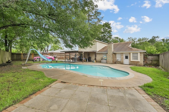 view of pool with a fenced backyard, a fenced in pool, a water slide, and a patio area
