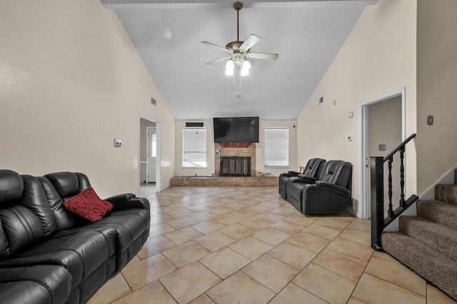 living area with a fireplace, high vaulted ceiling, a ceiling fan, light tile patterned floors, and stairway
