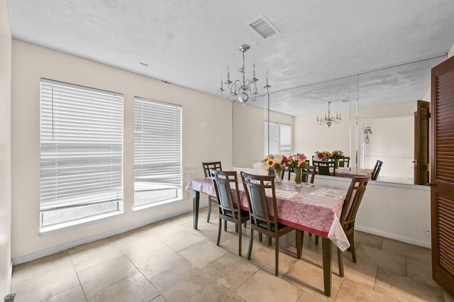dining room featuring an inviting chandelier, visible vents, baseboards, a textured ceiling, and light tile patterned floors