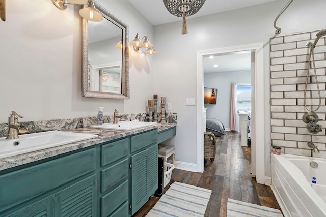 full bath with a sink, ensuite bath, double vanity, and shower / washtub combination