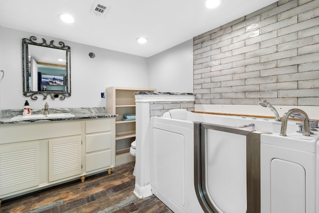 laundry area with dark wood-style flooring, laundry area, a sink, recessed lighting, and visible vents