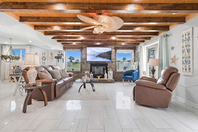 living area featuring a ceiling fan, a stone fireplace, beam ceiling, wooden ceiling, and baseboards
