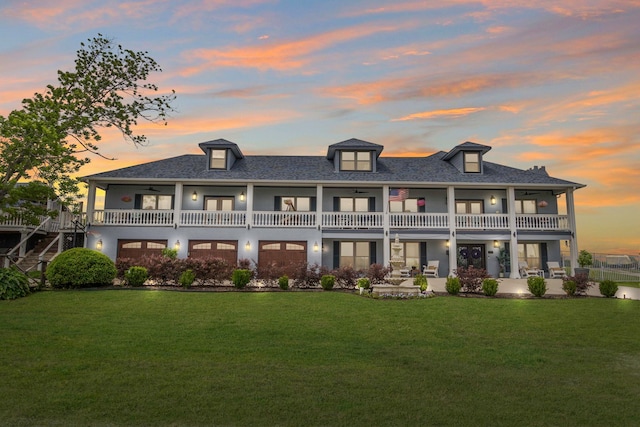 rear view of property featuring a lawn, ceiling fan, and a balcony