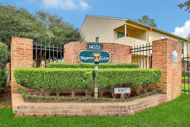 community / neighborhood sign with fence