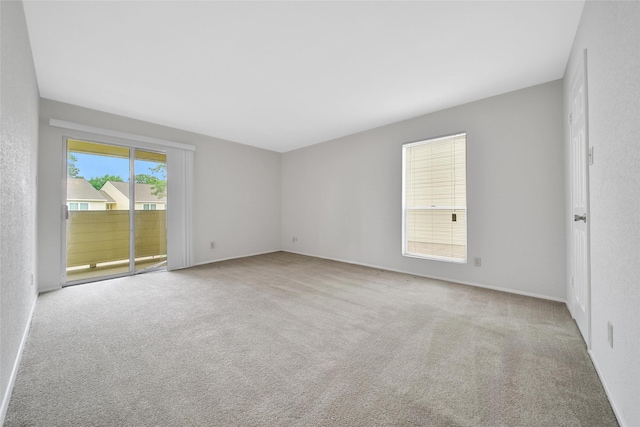 spare room featuring carpet floors and baseboards