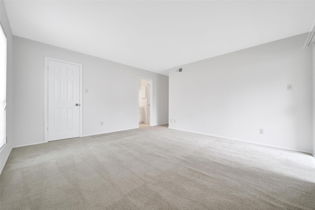 unfurnished room with baseboards, light colored carpet, and visible vents