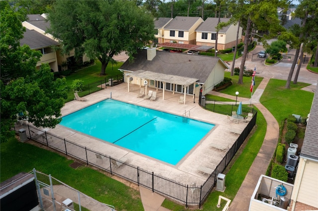 pool featuring a lawn, a residential view, a patio area, fence, and a pergola