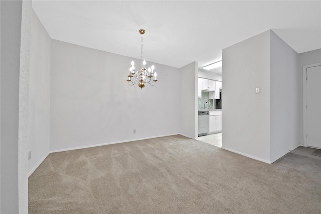 spare room featuring baseboards, a chandelier, and light carpet