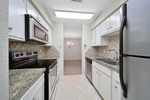 14515 Wunderlich Dr Unit 1602, Houston, TX 77069 - kitchen featuring white cabinets, a sink, a chandelier, stainless steel appliances, and light tile patterned floors