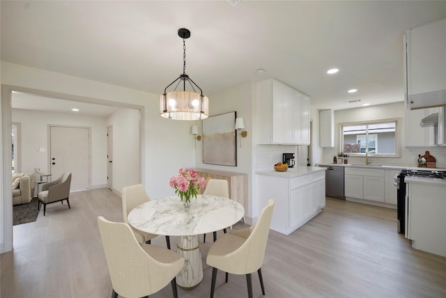 dining space featuring recessed lighting, a notable chandelier, and light wood-style flooring
