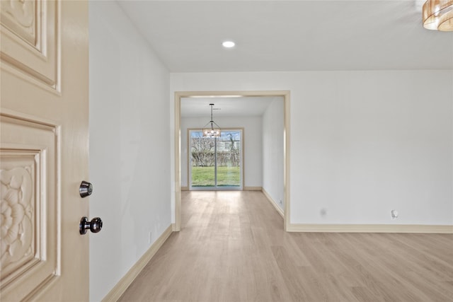 corridor with baseboards, recessed lighting, light wood-style flooring, and a chandelier