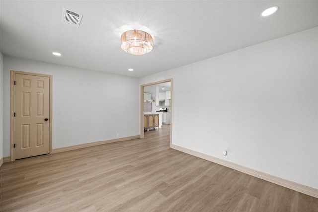unfurnished room with visible vents, baseboards, recessed lighting, a chandelier, and light wood-style flooring