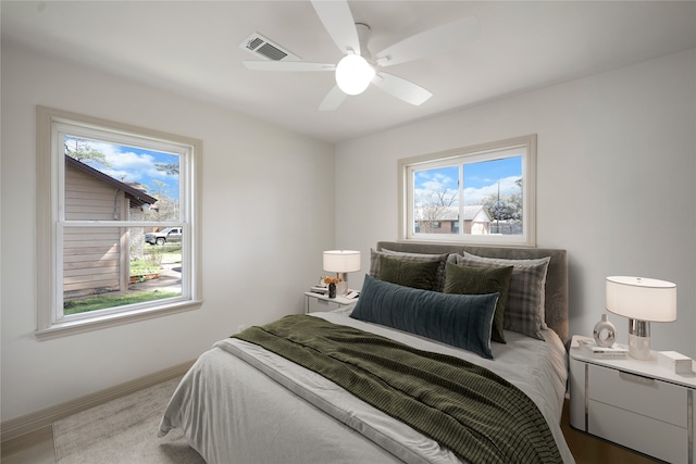 bedroom with baseboards, multiple windows, ceiling fan, and visible vents