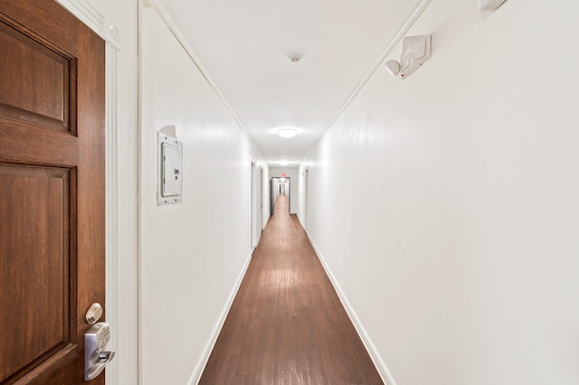 hall with baseboards and wood finished floors