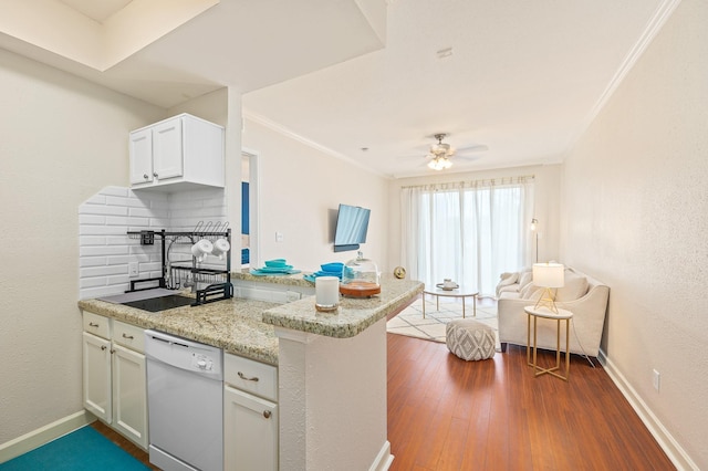 kitchen with white cabinets, dishwasher, a peninsula, open floor plan, and baseboards