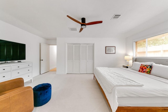 bedroom featuring ceiling fan, a closet, light colored carpet, and visible vents