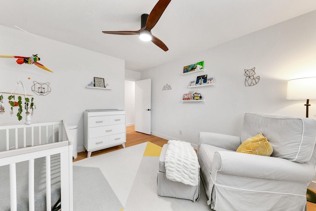 bedroom with light wood-type flooring, a ceiling fan, and baseboards