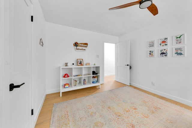 game room featuring ceiling fan, baseboards, and light wood-style floors