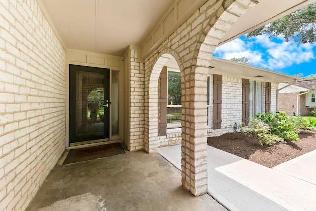 view of exterior entry featuring brick siding