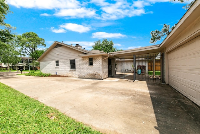 view of side of property with concrete driveway and brick siding