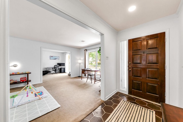 foyer entrance with crown molding, baseboards, and dark carpet
