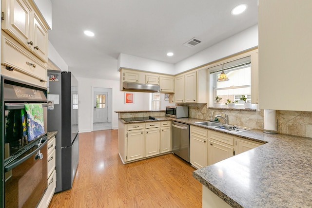 kitchen featuring a sink, stainless steel appliances, a peninsula, a healthy amount of sunlight, and visible vents