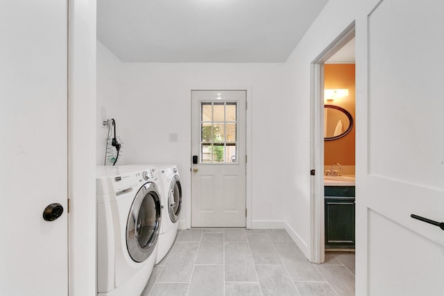 clothes washing area featuring separate washer and dryer, baseboards, laundry area, and light tile patterned flooring