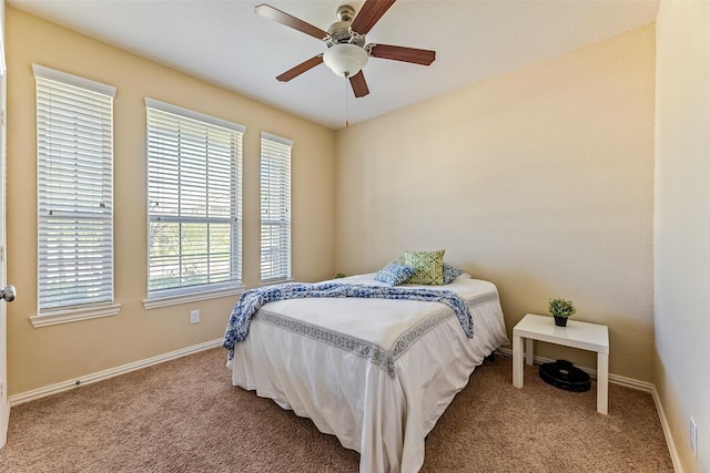 carpeted bedroom featuring baseboards and a ceiling fan