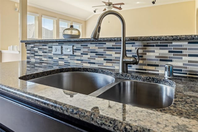 details featuring crown molding, ceiling fan, a sink, dark stone counters, and tasteful backsplash