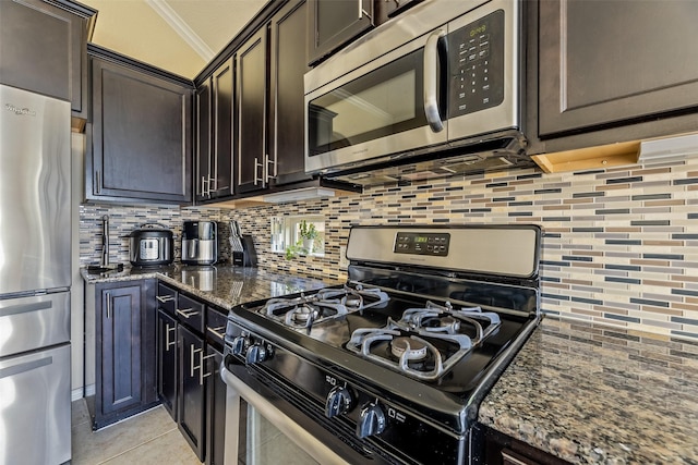 kitchen featuring crown molding, stainless steel appliances, tasteful backsplash, and dark stone countertops