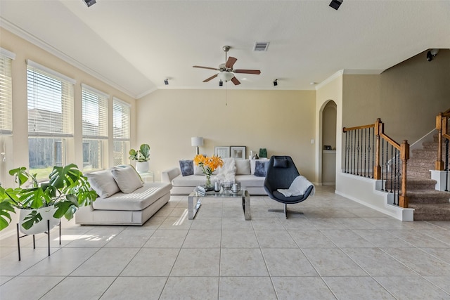 living room featuring light tile patterned floors, arched walkways, crown molding, and a ceiling fan