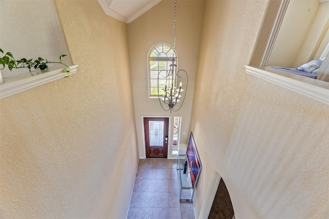 entryway featuring a healthy amount of sunlight, a textured wall, and a towering ceiling