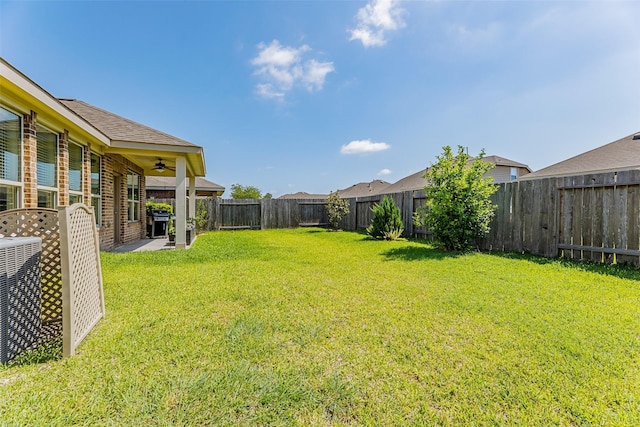 view of yard featuring a ceiling fan and a fenced backyard