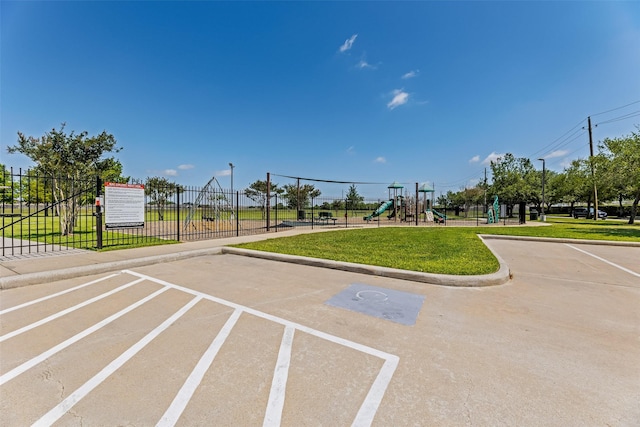 surrounding community featuring fence, a yard, uncovered parking, and playground community