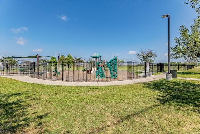 community jungle gym with a lawn and fence