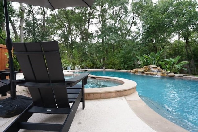 outdoor pool featuring an in ground hot tub