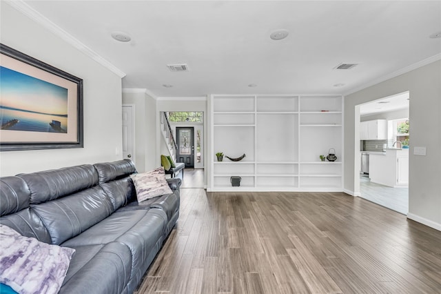 living area featuring crown molding, wood finished floors, and visible vents