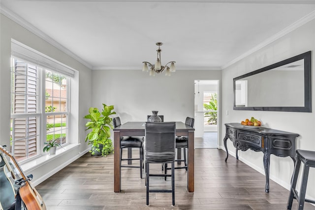 dining area with baseboards, ornamental molding, wood finished floors, and a chandelier