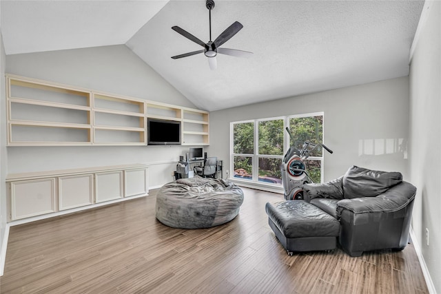 living room with a ceiling fan, high vaulted ceiling, and wood finished floors