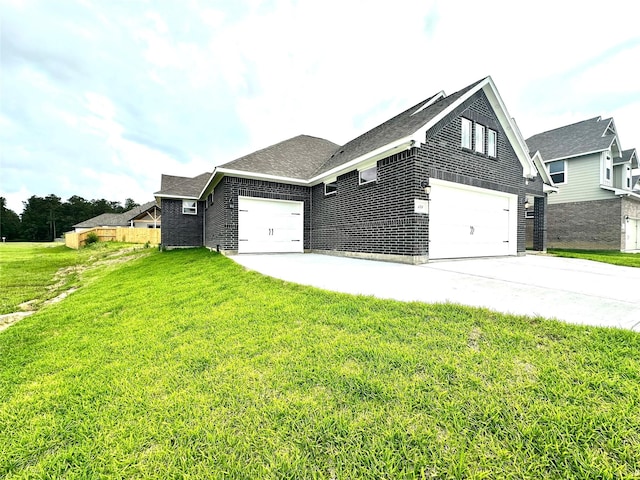 view of side of home featuring brick siding, a garage, a yard, and concrete driveway