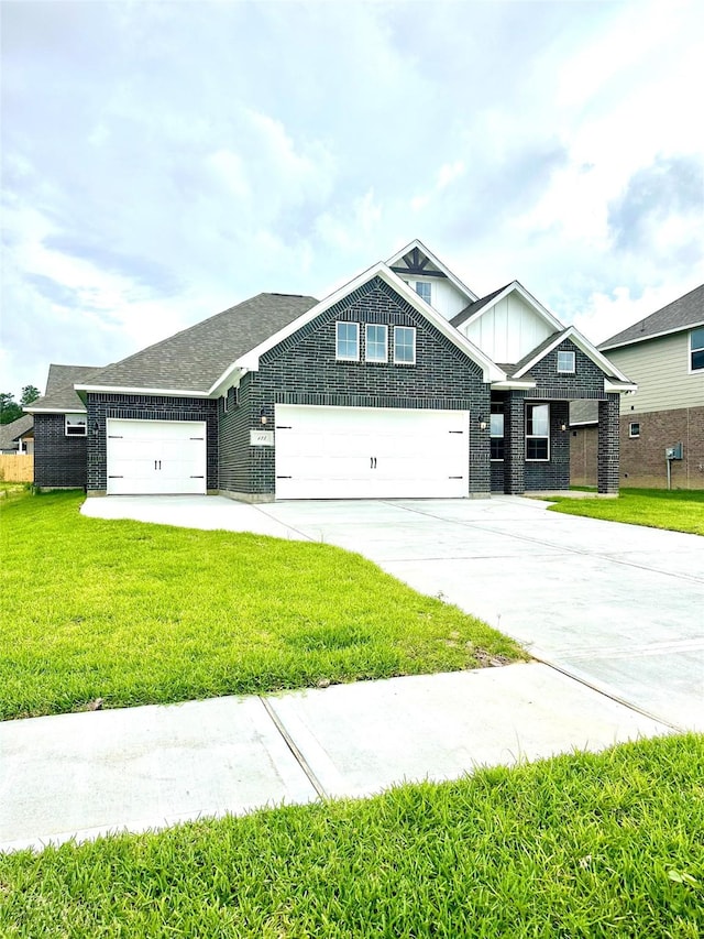 craftsman-style home with board and batten siding, brick siding, a front yard, and a garage
