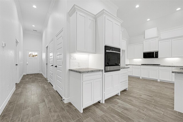 123 Big Spring Dr, Anahuac, TX 77514 - kitchen featuring black appliances, crown molding, decorative backsplash, white cabinets, and light stone counters