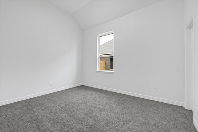 123 Big Spring Dr, Anahuac, TX 77514 - empty room featuring dark carpet, lofted ceiling, and baseboards