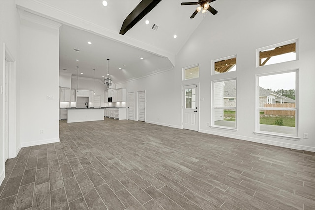123 Big Spring Dr, Anahuac, TX 77514 - unfurnished living room with beam ceiling, high vaulted ceiling, a ceiling fan, wood finished floors, and baseboards