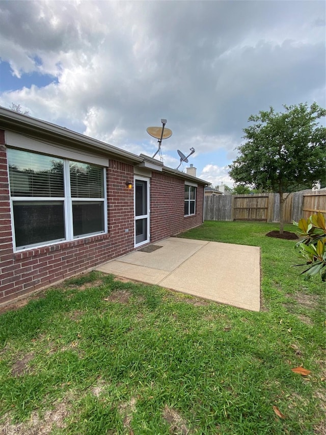 3006 Red Stag Pass, Missouri City, TX 77459 - back of property featuring brick siding, a fenced backyard, a patio area, and a lawn