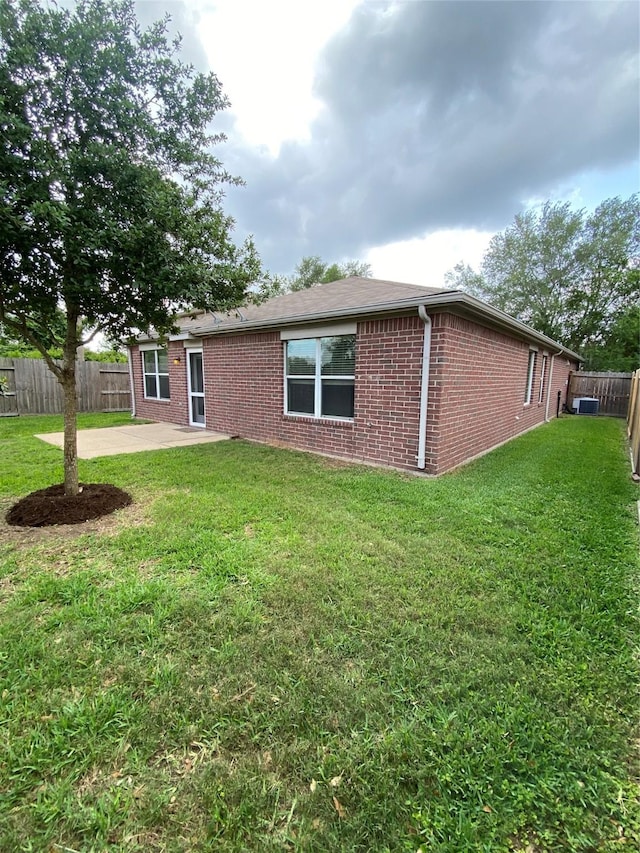 3006 Red Stag Pass, Missouri City, TX 77459 - back of house with brick siding, a fenced backyard, a yard, and a patio