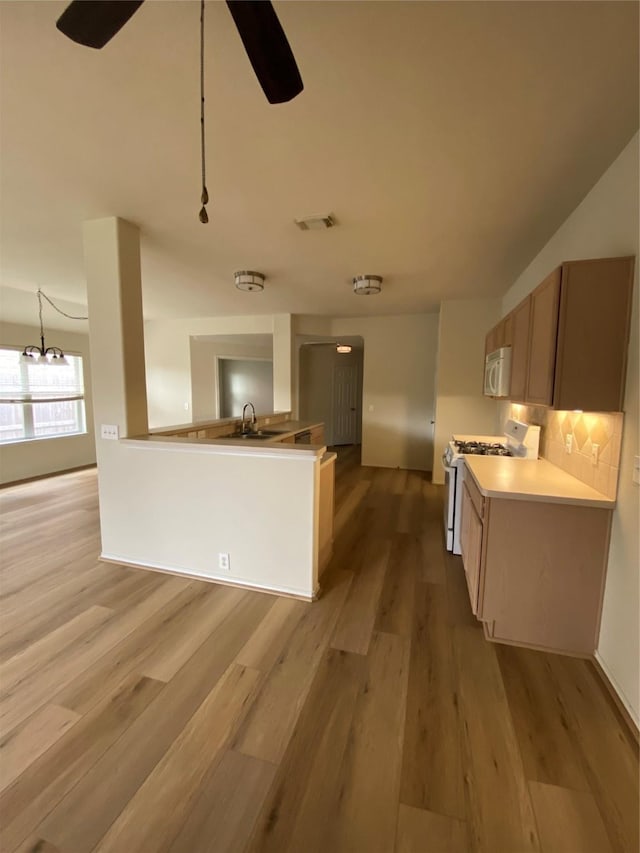 3006 Red Stag Pass, Missouri City, TX 77459 - kitchen with white appliances, light wood-style flooring, ceiling fan with notable chandelier, tasteful backsplash, and visible vents